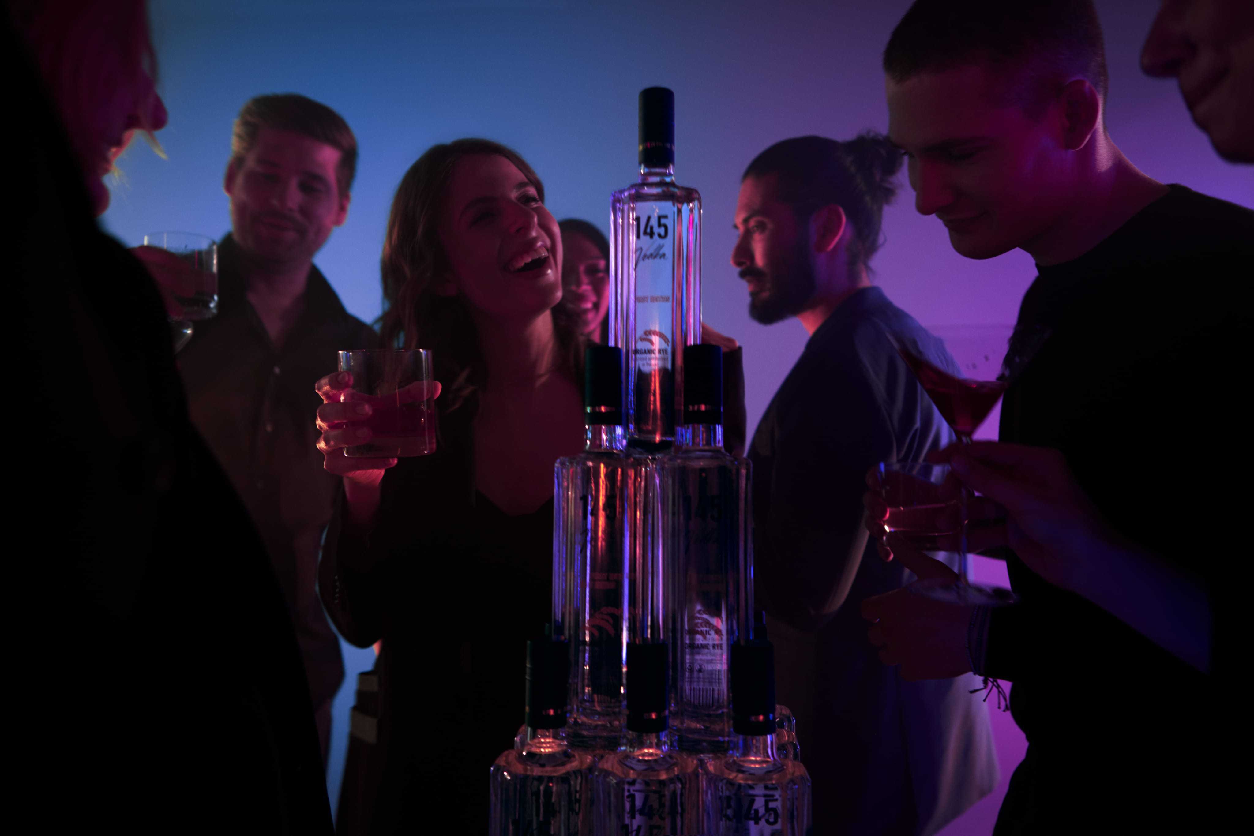 Happy dancing people with 145 Vodka bottle tower